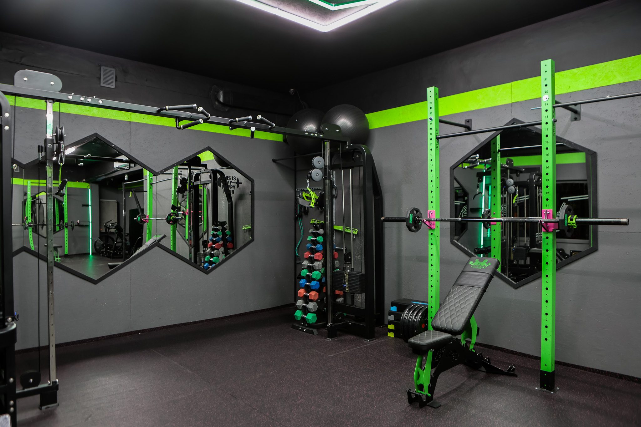 Sala treningowa z klatką, lustrami i stojakiem na hantle – Fit&Fizjo Studio