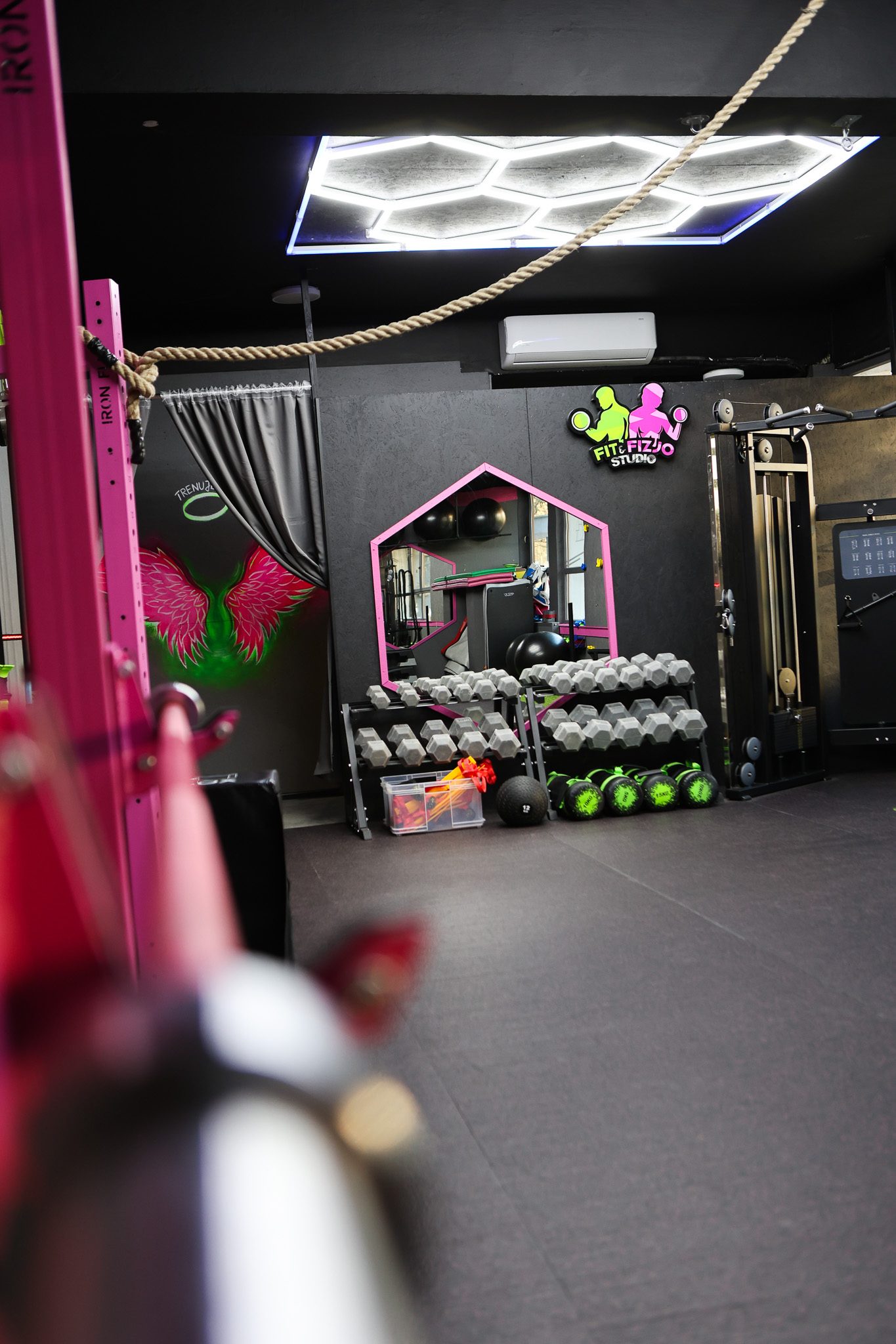 Sala treningowa z liną wspinaczkową i stojakami na hantle – Fit&Fizjo Studio