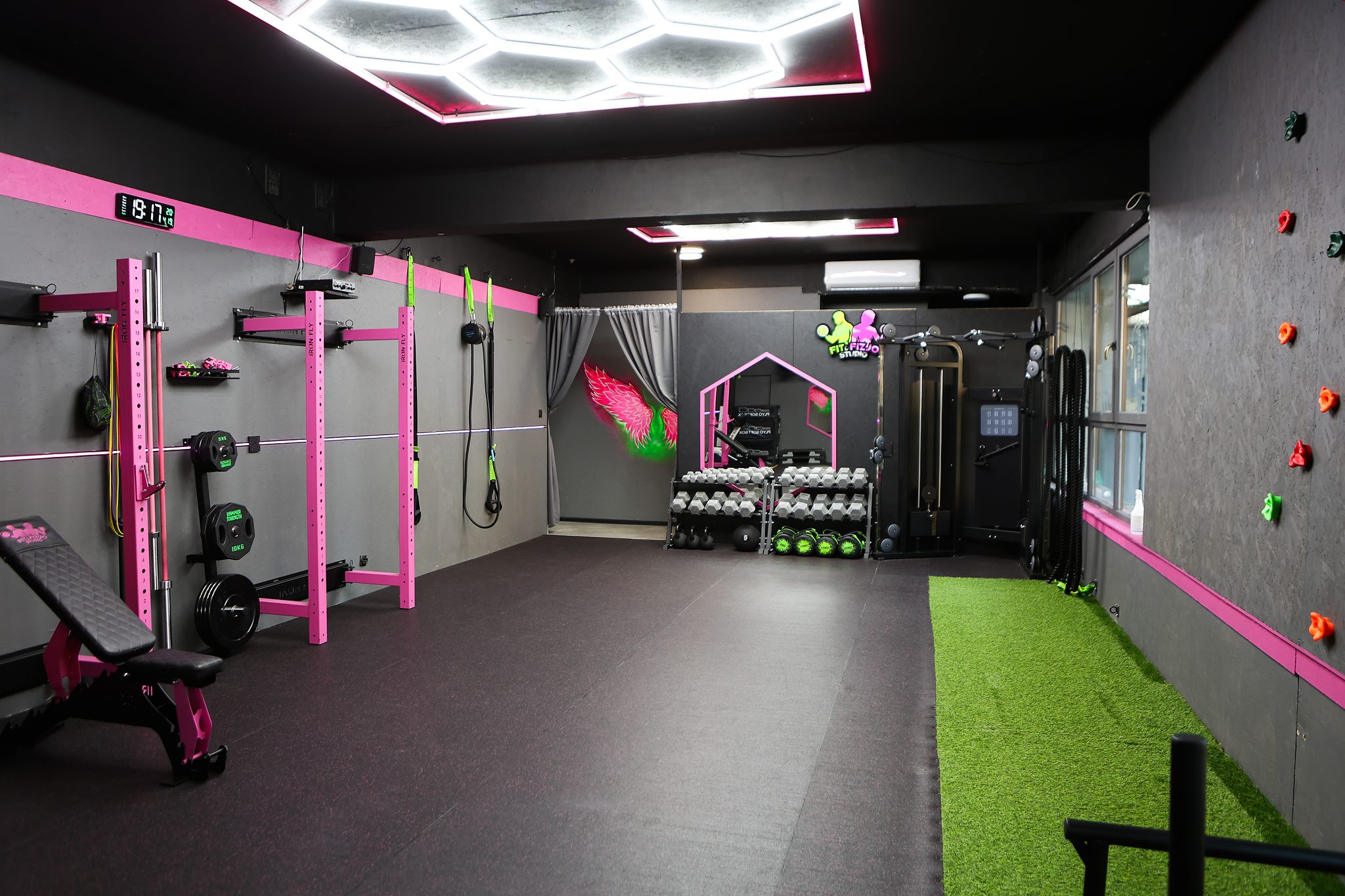 Panorama sali z torem z trawy i ścianką wspinaczkową – Fit&Fizjo Studio
