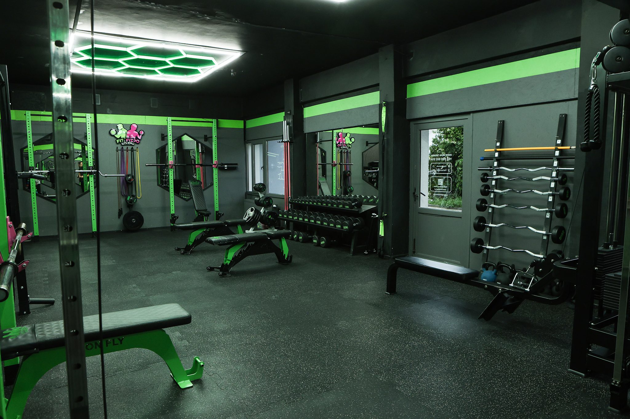 Panorama sali z ławkami i stojakiem na gryfy – Fit&Fizjo Studio